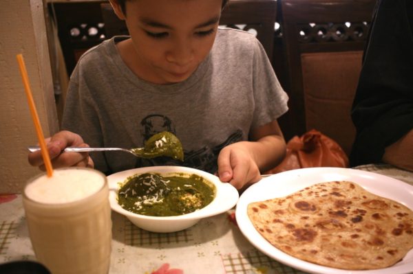 パラタ（右）に、ほうれん草とパニール（チーズ）のコフタ、マンゴーラッシー。タイ料理を食べない息子も、インド料理はパクパク。My son eating a plain paratha, palak kofta, and a mango lassi.  Little India, Bangkok